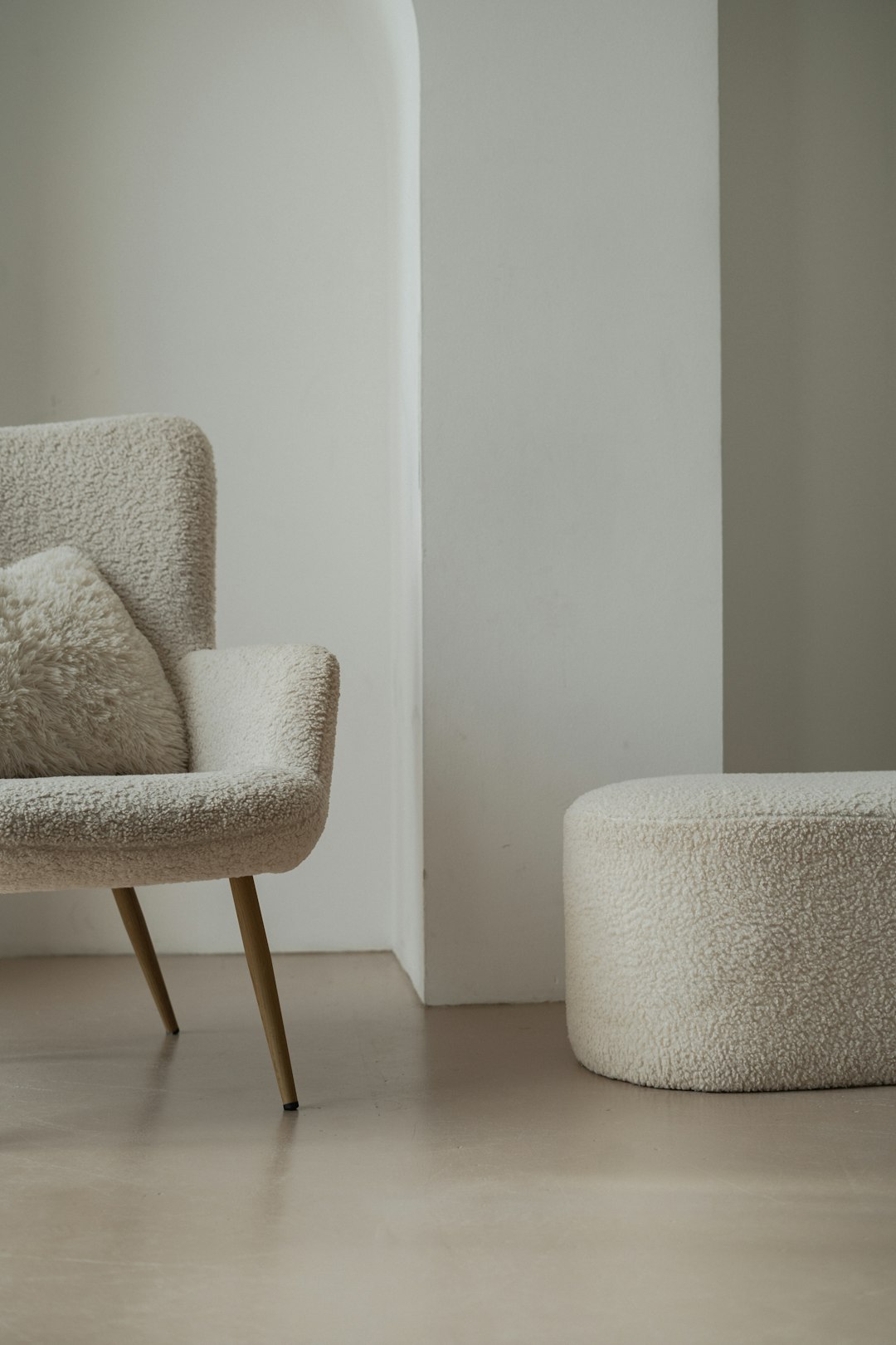 a-white-chair-and-ottoman-in-a-room-kjklaw8xome